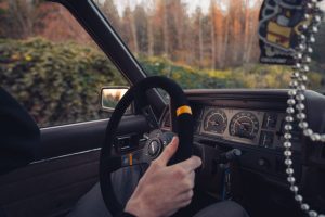 View of a car dashboard and steering wheel while driving, representing car insurance