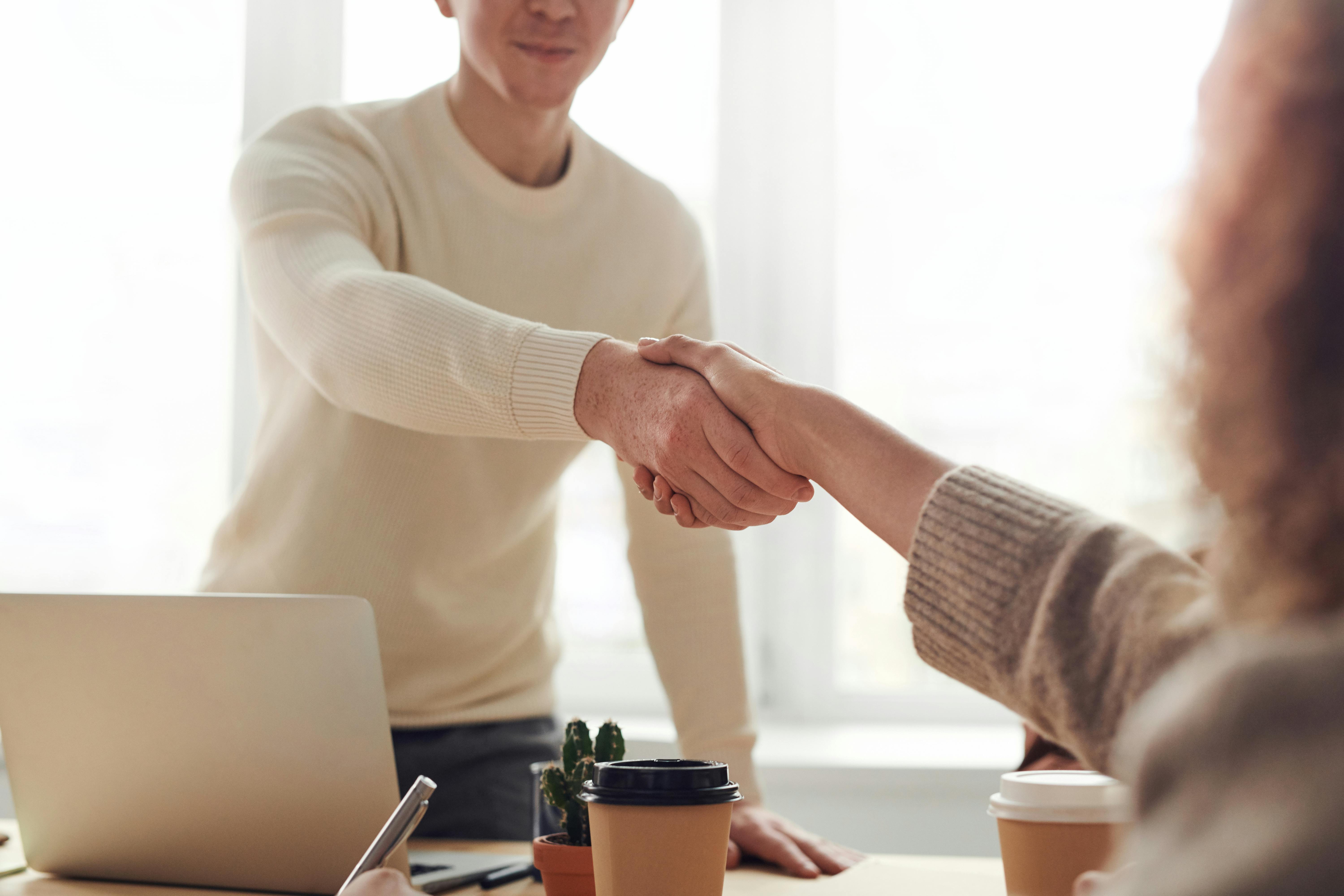 Professional handshake representing a job offer in Germany