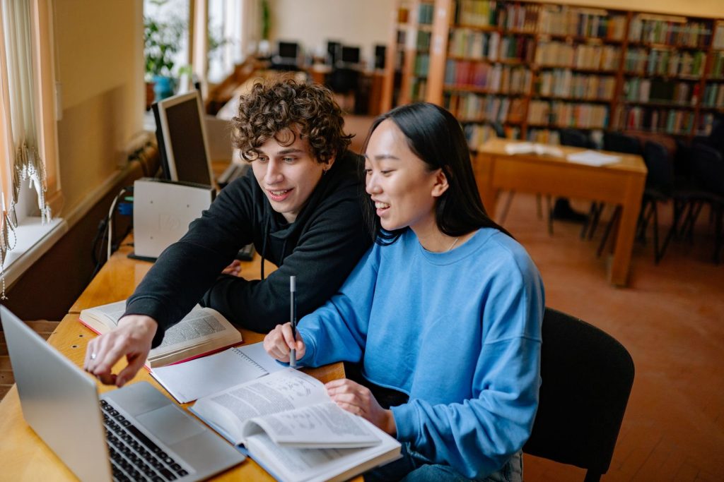 International students studying with a laptop in a university library