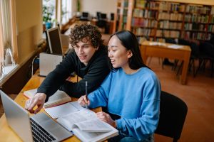 International students studying with a laptop in a university library