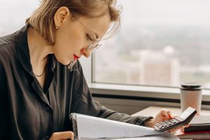 Person working with calculator and tax documents to submit a Freistellungsauftrag in Germany