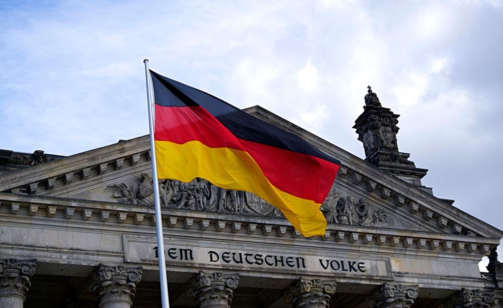 German flag fluttering in front of official building in autumn October 2026
